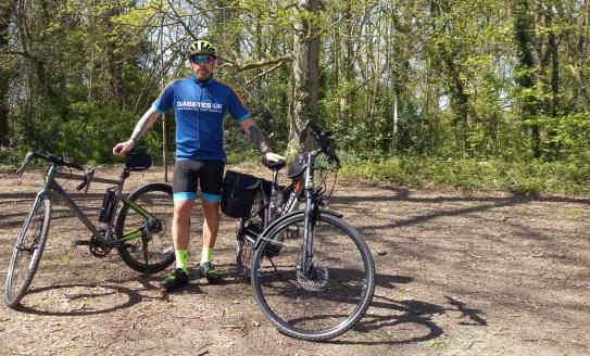 Brian wearing his Diabetes UK top and standing with his bike 