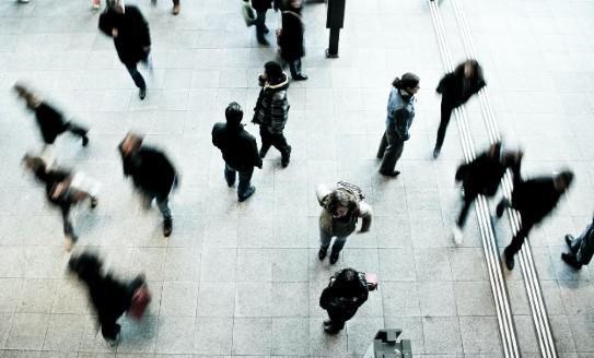 A time lapse photo taken from above of people walking on a city street